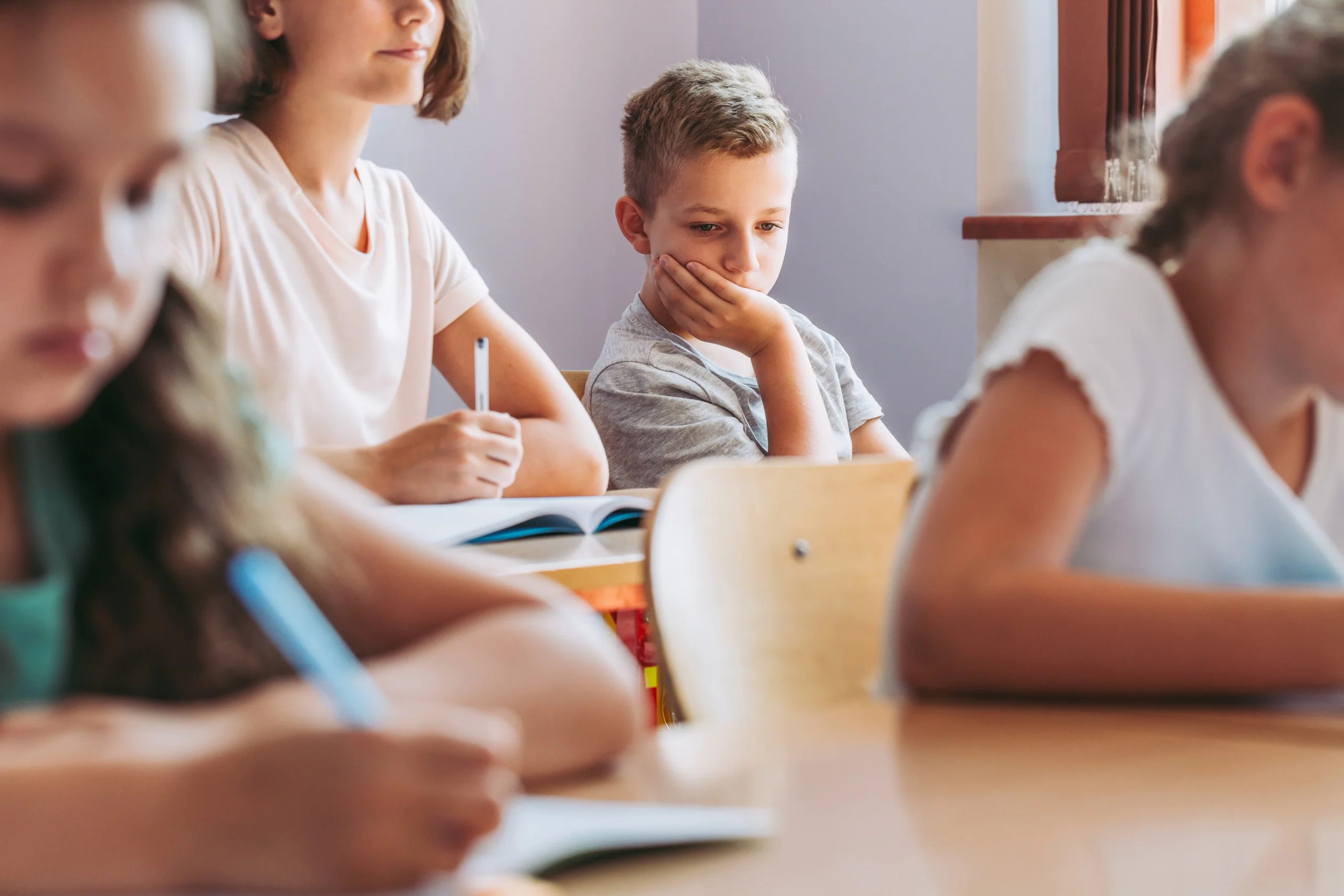 Czy mikrobiom może wpływać na zdrowie psychiczne dzieci? Smutny chłopiec siedzi sam w ostatniej ławce w klasie.