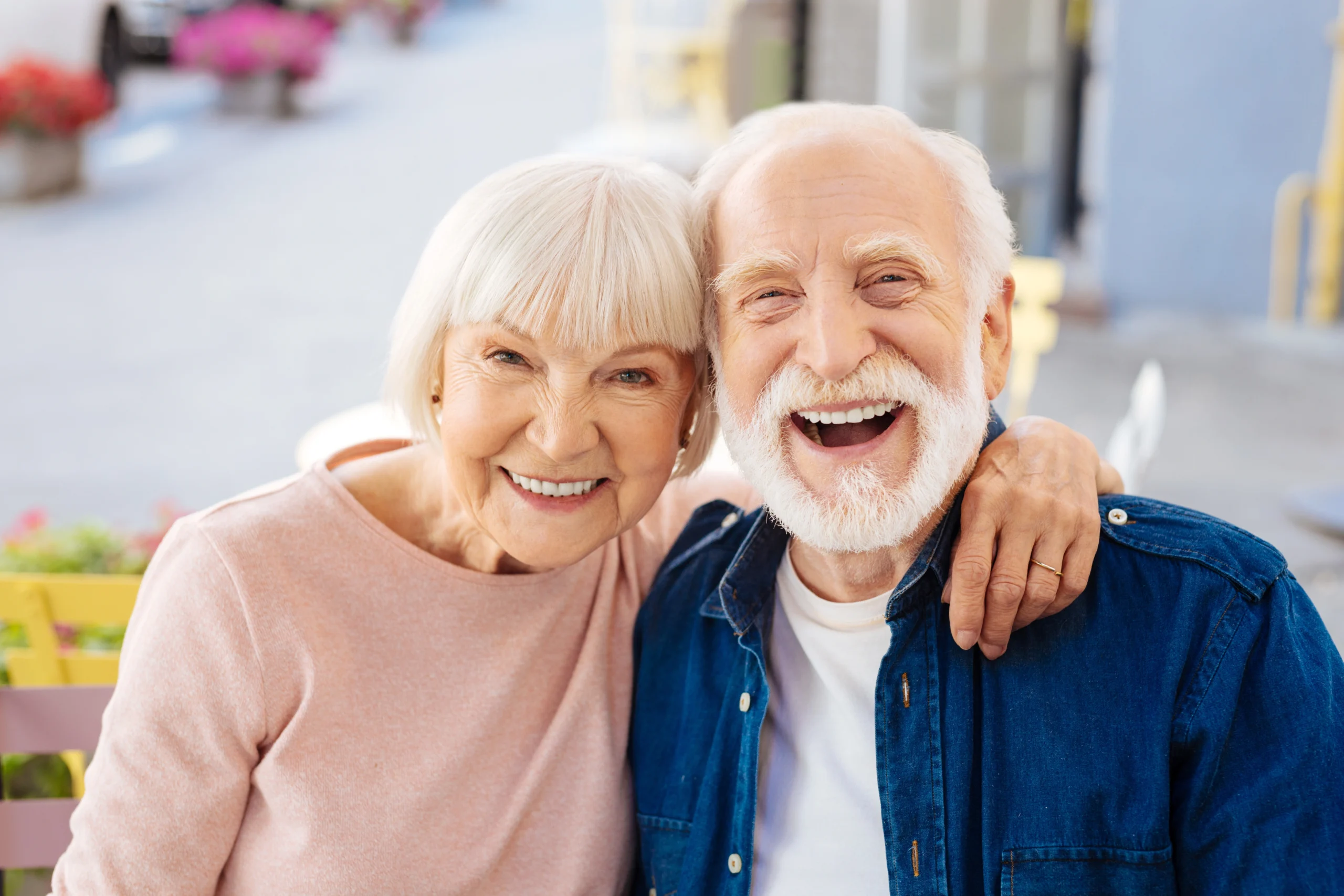 W jaki sposób mikrobiom zmienia się wraz ze starzeniem się organizmu? Dlaczego osoby 60+ potrzebują dedykowanego produktu? Uśmiechnięta para seniorów w domu uśmiecha się do obiektywu.